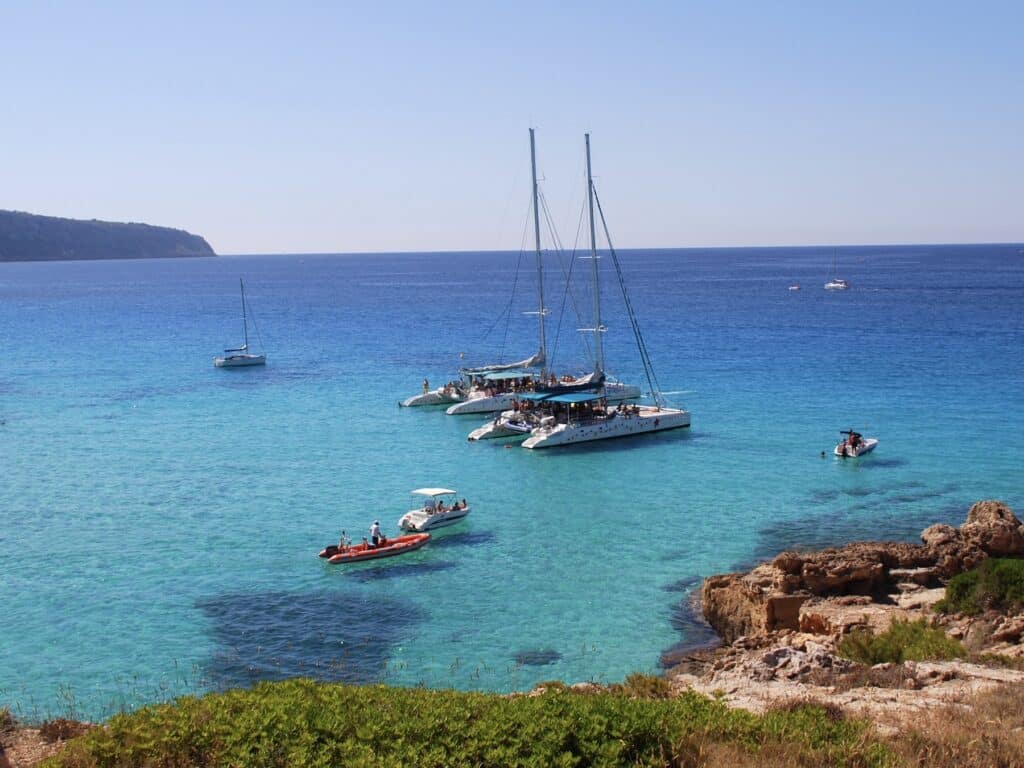 Boote im türkisblauen Meer vor Küste
