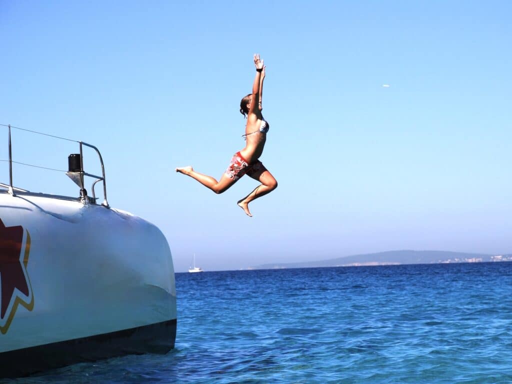 Frau springt vom Boot ins Meer