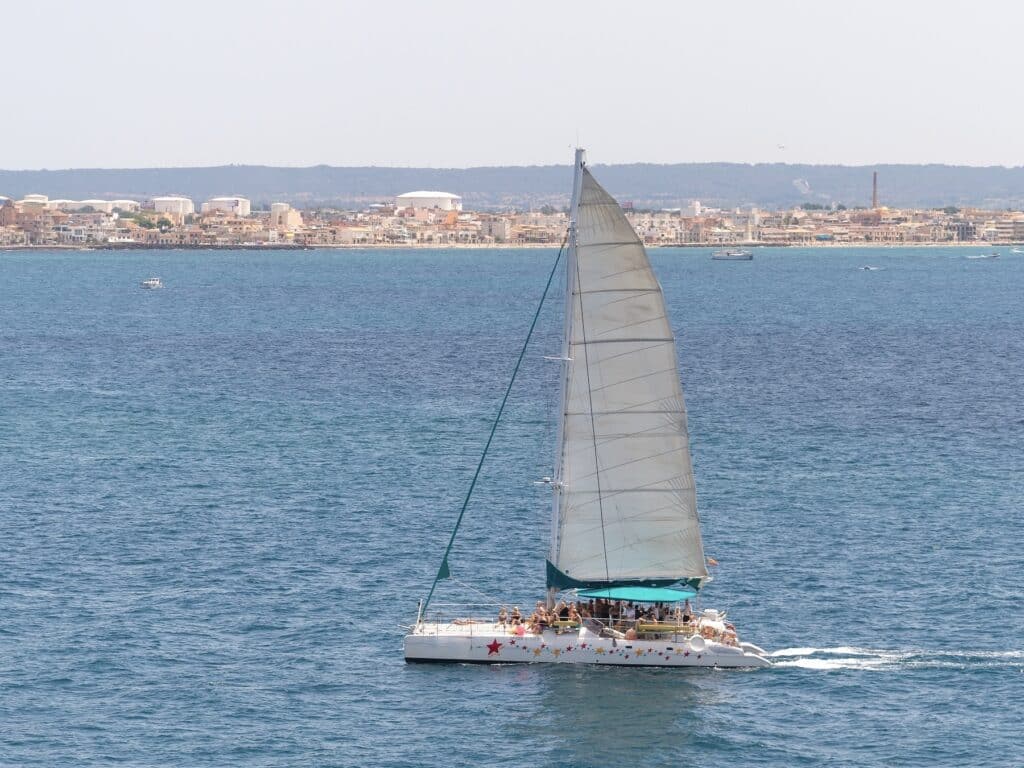 Segelboot auf dem Meer, Stadt im Hintergrund