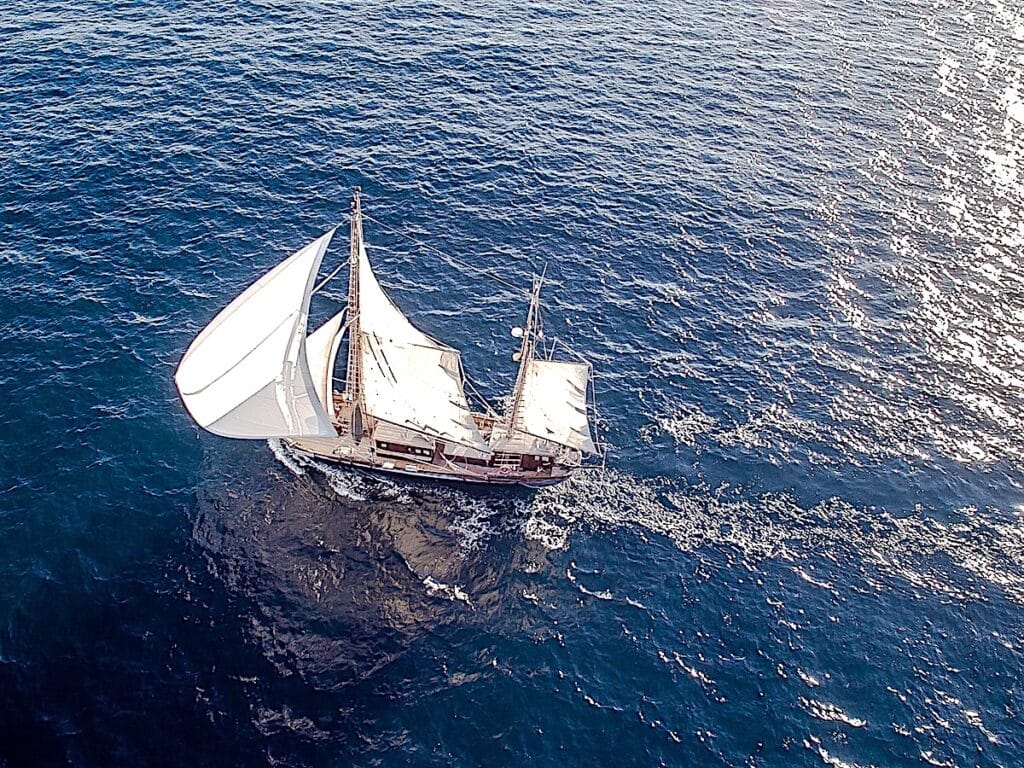 Segelschiff auf blauem Meer (Luftaufnahme)