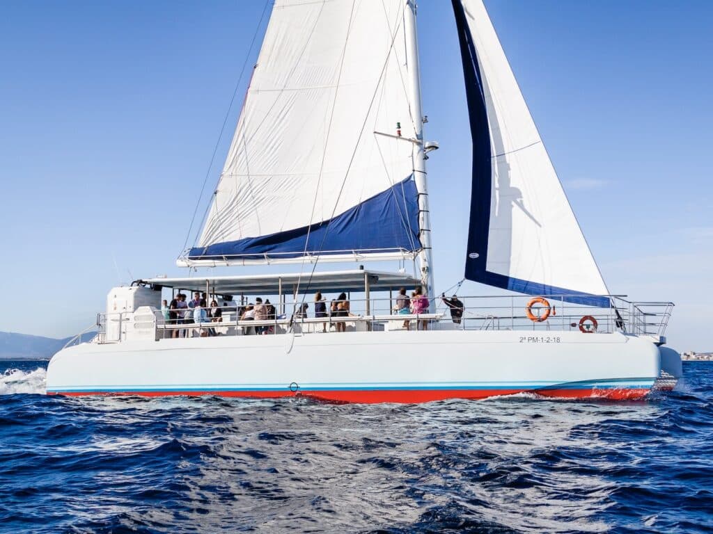 Segelboot mit Passagieren auf blauem Meer