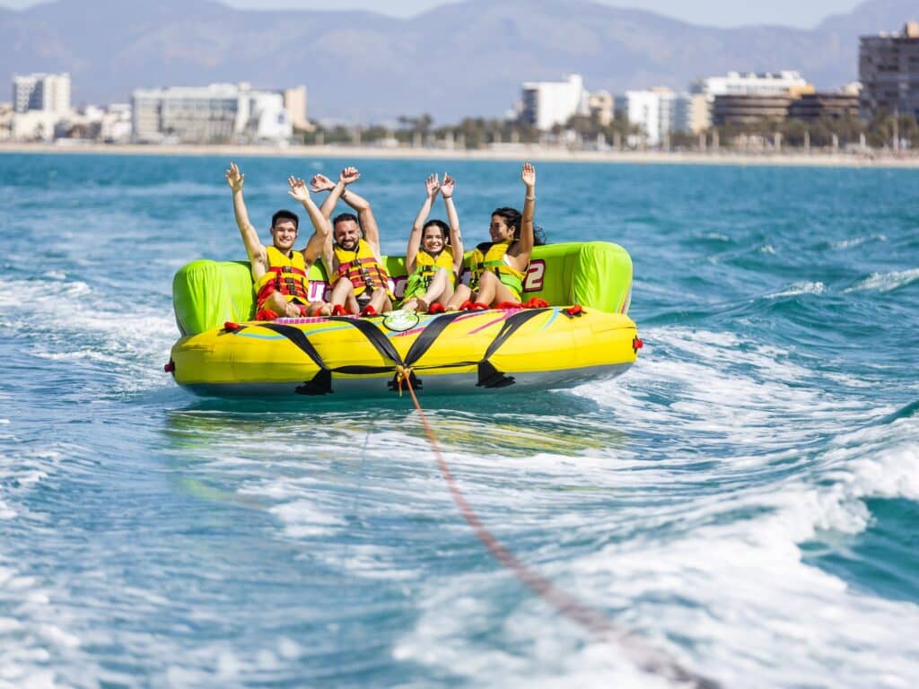Personen auf Tube hinter Boot